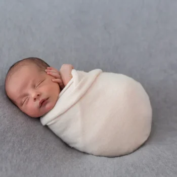 newborn baby wrapped with soft pink tissue
