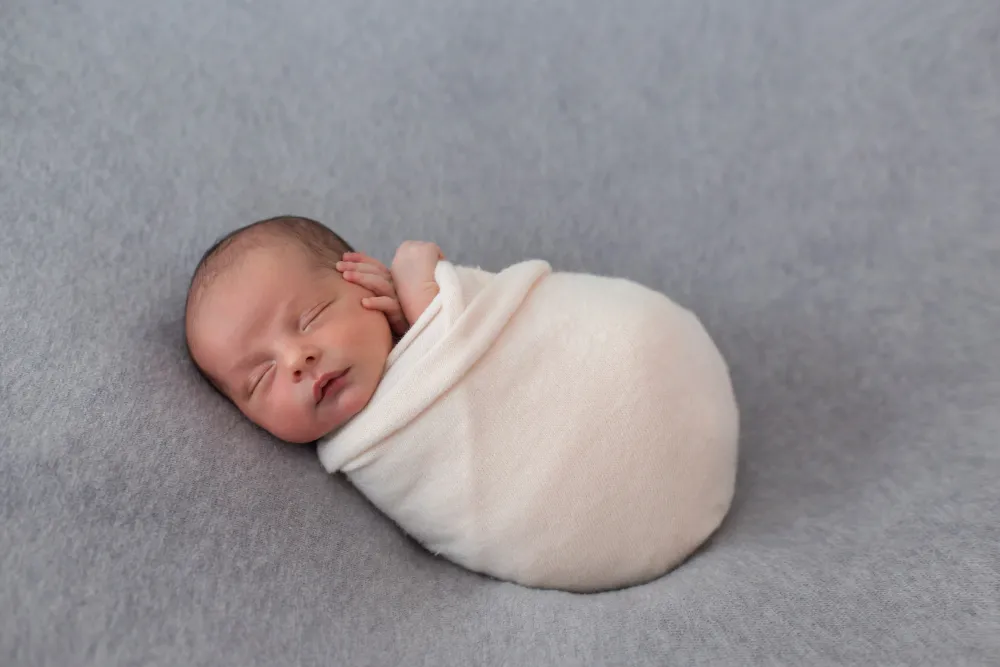 newborn baby wrapped with soft pink tissue